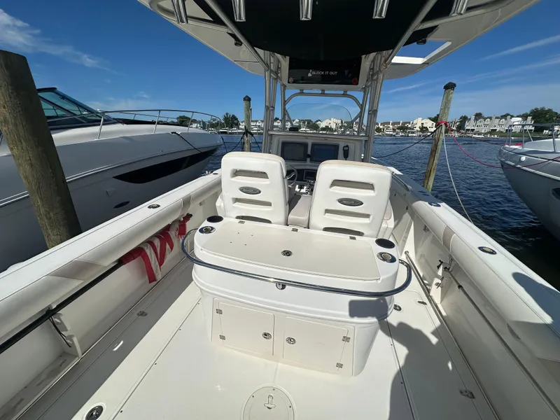 Slide: The Image of 2005 Boston Whaler 320 Outrage boat interior at dock, featuring helm and seating area. - 33