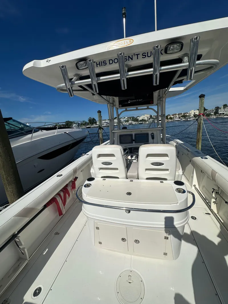Slide: The Image of 2005 Boston Whaler 320 Outrage boat interior with seating and storage, docked by the water. - 34