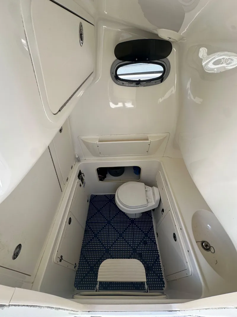 Slide: The Image of Interior of a 2005 Boston Whaler 320 Outrage boat, featuring a compact marine toilet. - 35
