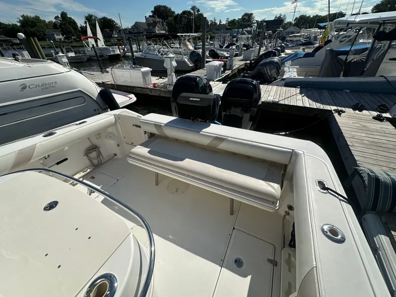 Slide: The Image of 2005 Boston Whaler 320 Outrage at marina, featuring spacious seating and dual outboard engines. - 38