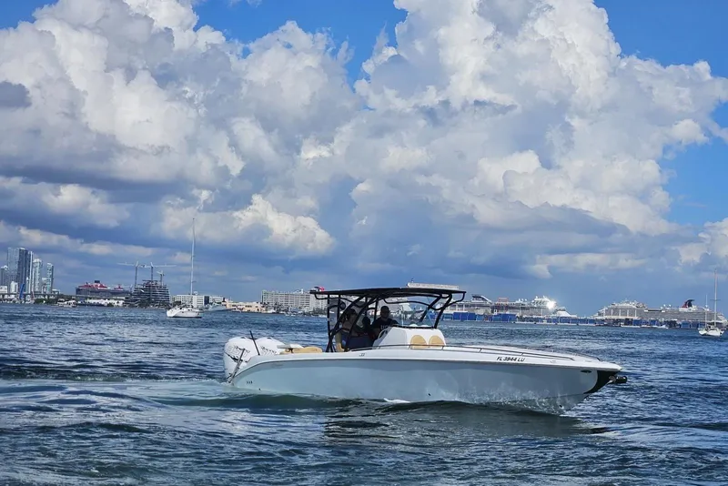 Slide: The Image of 2002 Baja 340 Islander Outboard cruising on a sunny day with cityscape background. - 16