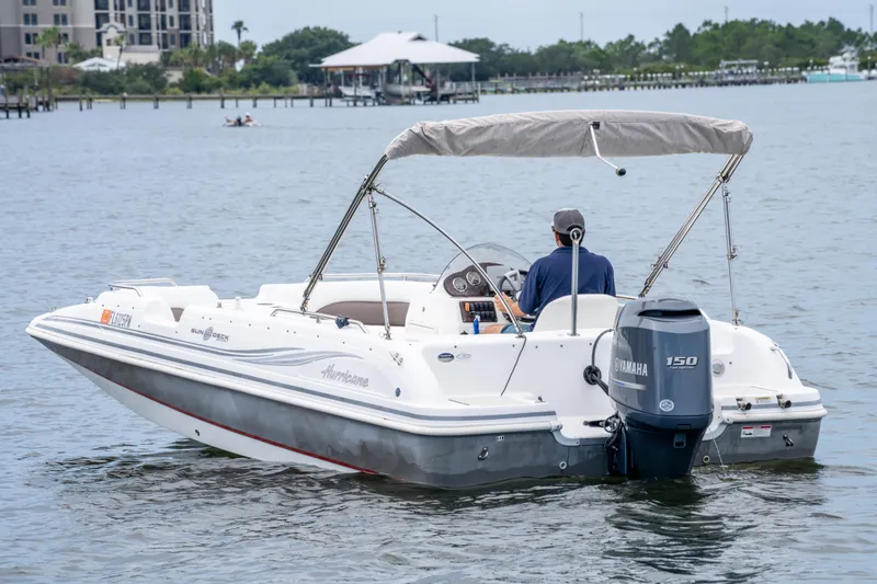 Slide: The Image of 2013 Hurricane SunDeck Sport 201 OB boat cruising on a calm lake with a Yamaha engine. - 11
