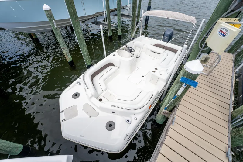 Slide: The Image of 2013 Hurricane SunDeck Sport 201 OB boat docked at a marina. - 13