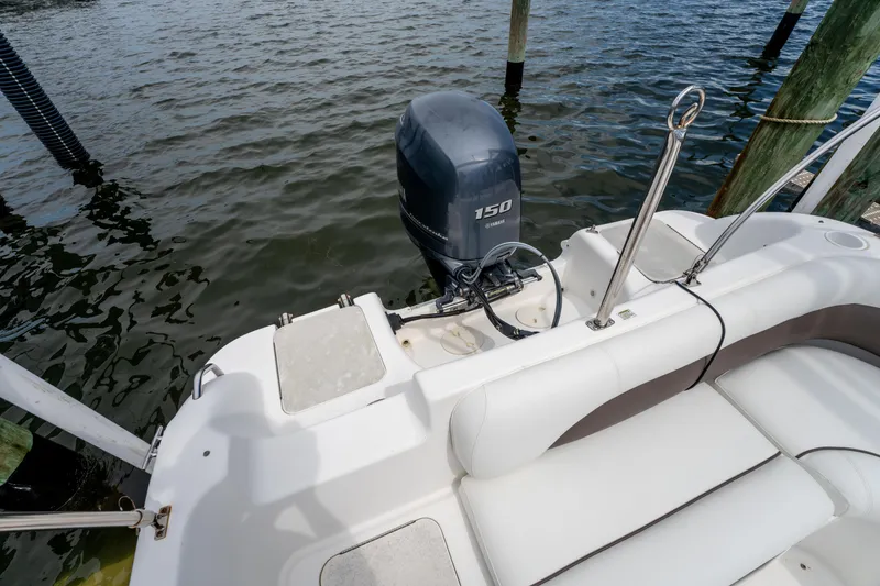 Slide: The Image of 2013 Hurricane SunDeck Sport 201 OB boat with Yamaha 150 engine, docked by water. - 15