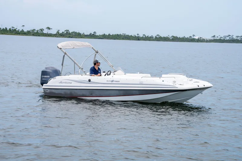 Slide: The Image of 2013 Hurricane SunDeck Sport 201 OB boat cruising on calm water. - 2