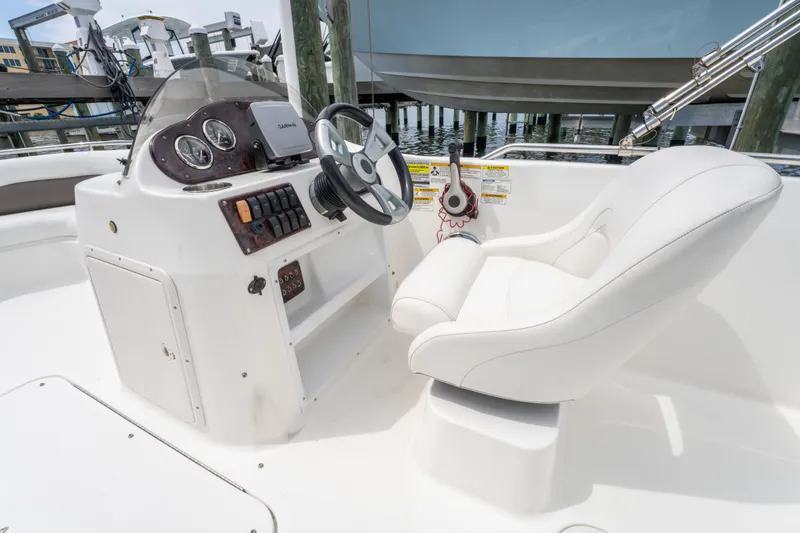 Slide: The Image of 2013 Hurricane SunDeck Sport 201 OB boat helm with white captain's chair and control panel. - 20