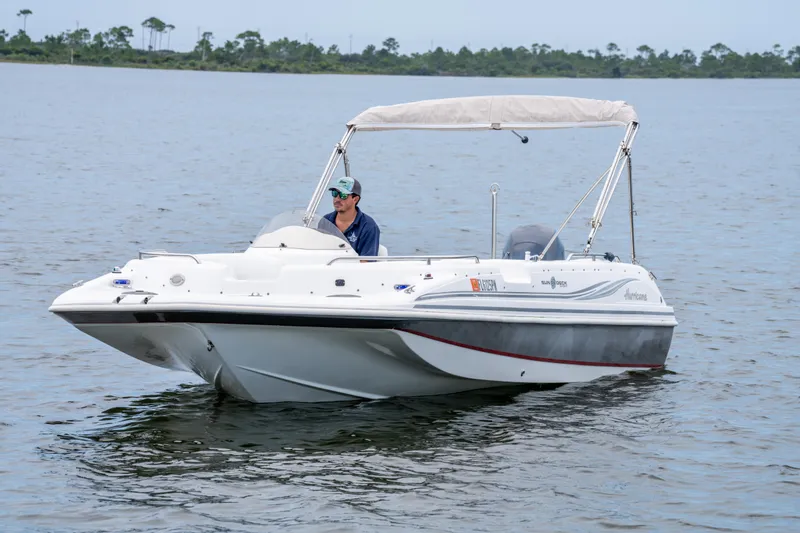 Slide: The Image of 2013 Hurricane SunDeck Sport 201 OB boat cruising on calm water. - 5