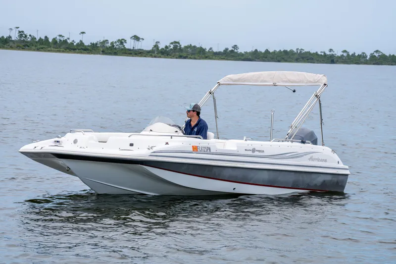 Slide: The Image of 2013 Hurricane SunDeck Sport 201 OB boat on calm water with canopy. - 6
