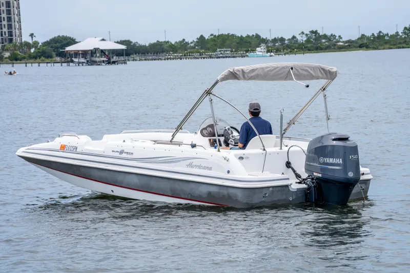 Slide: The Image of 2013 Hurricane SunDeck Sport 201 OB boat on water, featuring Yamaha 150 engine. - 9