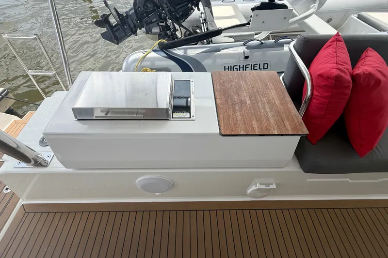 Slide: The Image of 2023 Fountaine Pajot Aura 51 yacht deck with grill, seating, and red cushions. - 42