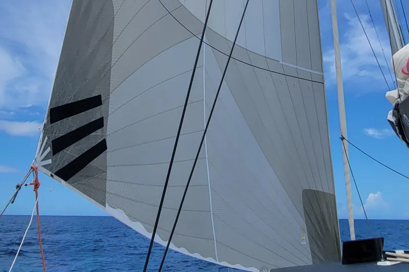Slide: The Image of Sailing on a 2023 Fountaine Pajot Aura 51 catamaran with sails unfurled against a blue sky. - 48