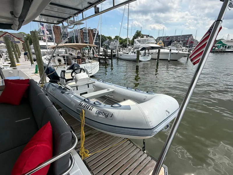 Slide: The Image of 2023 Fountaine Pajot Aura 51 yacht docked with inflatable boat, marina view. - 8