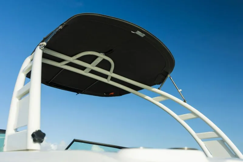 Slide: The Image of Manufacturer Provided Image: 2022 NauticStar 243 DC boat with a black bimini top against a clear blue sky. - 2