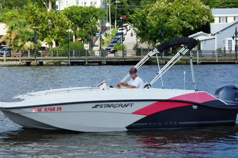 Slide: The Image of 2017 Starcraft Star Step 221 OB boat cruising on a river with a person at the helm. - 2