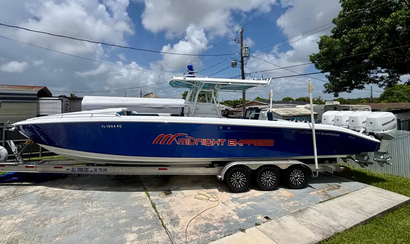 The Image of 2007 Midnight Express 39 Cuddy boat on trailer, blue hull, parked outdoors. - 0