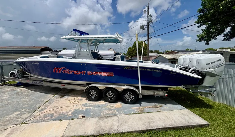 Slide: The Image of 2007 Midnight Express 39 Cuddy boat on trailer, featuring blue hull and Mercury engines. - 1
