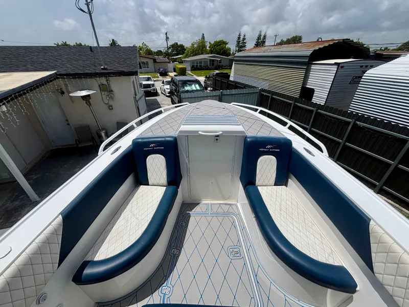 Slide: The Image of 2007 Midnight Express 39 Cuddy boat interior with blue and white seating, parked in a residential area. - 10