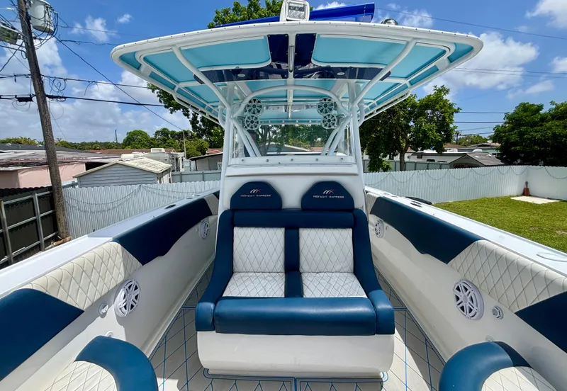 Slide: The Image of 2007 Midnight Express 39 Cuddy boat interior with blue and white seating under a sunny sky. - 13