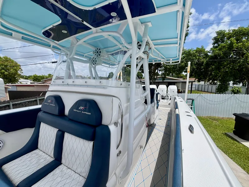 Slide: The Image of 2007 Midnight Express 39 Cuddy boat with blue and white seating, outdoor setting. - 16