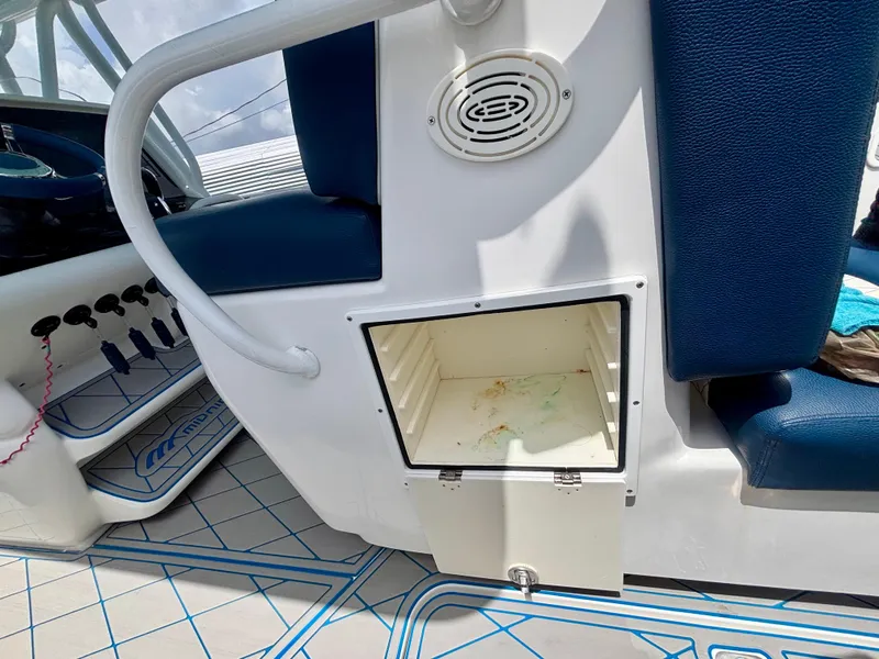 Slide: The Image of 2007 Midnight Express 39 Cuddy interior with open storage compartment and blue seating. - 36