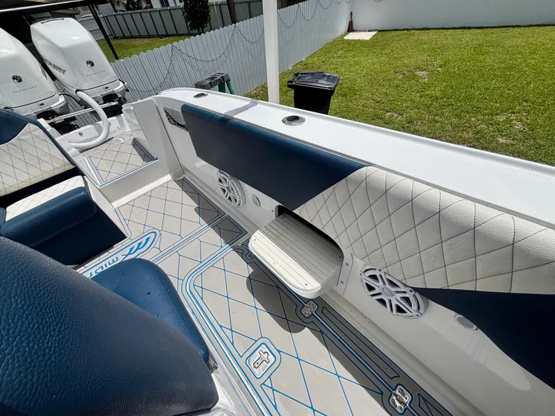 Slide: The Image of 2007 Midnight Express 39 Cuddy interior with blue and white seating, speakers, and twin engines. - 38