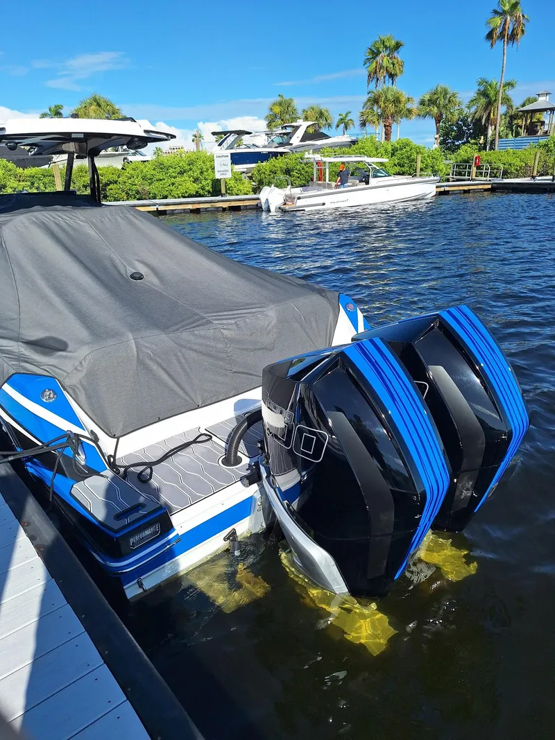 Slide: The Image of 2023 Sunsation 32 CCX boat docked with twin outboard engines, covered, in a sunny marina. - 18