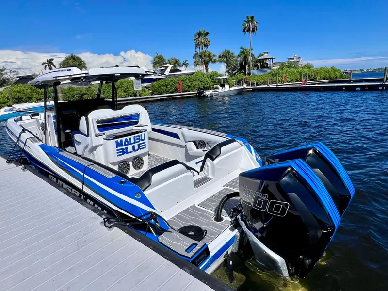 Slide: The Image of 2023 Sunsation 32 CCX boat docked, featuring dual engines and sleek blue design. - 19