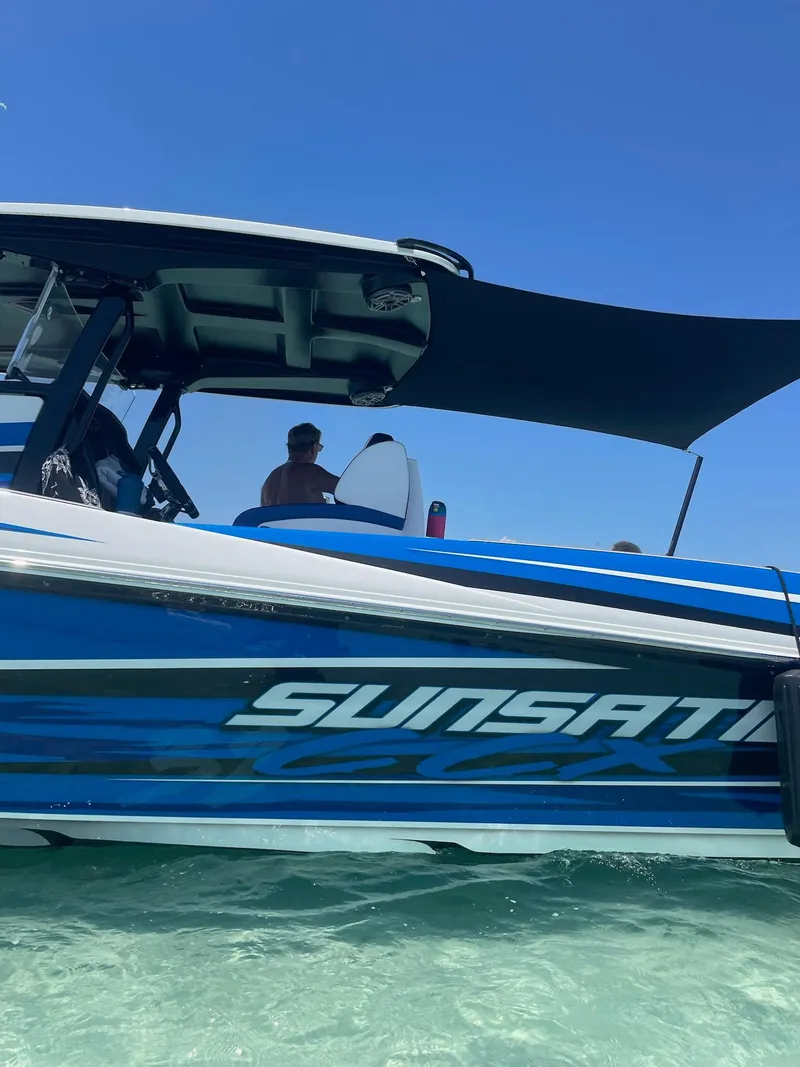 Slide: The Image of 2023 Sunsation 32 CCX boat on clear water under blue sky. - 2