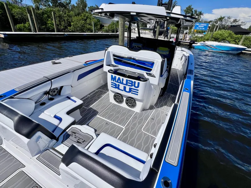 Slide: The Image of 2023 Sunsation 32 CCX boat with sleek design and "Malibu Blue" branding on deck. - 25