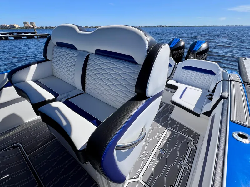 Slide: The Image of 2023 Sunsation 32 CCX boat interior with stylish seating and twin engines on a sunny day. - 30