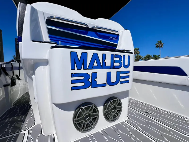 Slide: The Image of 2023 Sunsation 32 CCX boat with "Malibu Blue" branding and stylish speakers. - 34