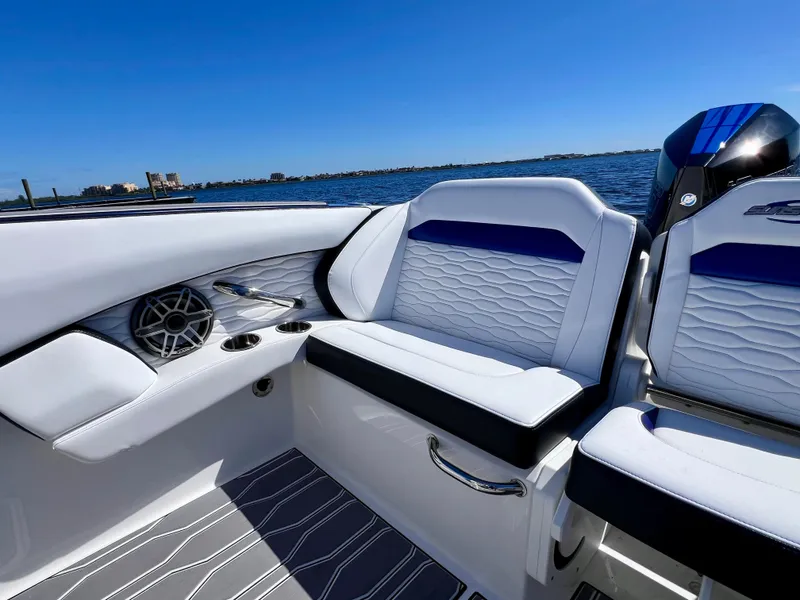 Slide: The Image of 2023 Sunsation 32 CCX boat interior with stylish seating and speaker, on a sunny day. - 37