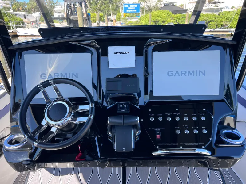 Slide: The Image of 2023 Sunsation 32 CCX boat dashboard with Garmin displays and Mercury controls. - 39