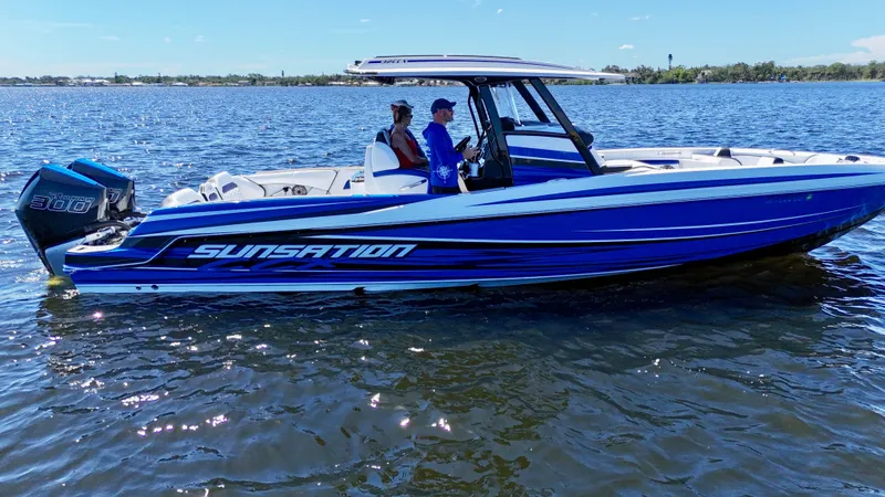 Slide: The Image of 2023 Sunsation 32 CCX boat on water, featuring sleek blue design and powerful engines. - 4