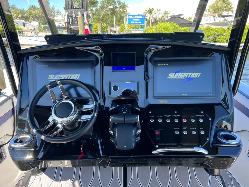 Slide: The Image of 2023 Sunsation 32 CCX boat dashboard with dual Garmin displays and sleek steering wheel. - 40