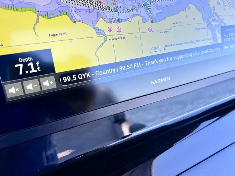 Slide: The Image of Garmin marine display showing depth and radio station on Sunsation 32 CCX, 2023 model. - 48