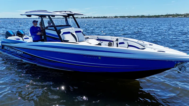 Slide: The Image of 2023 Sunsation 32 CCX boat on open water, featuring sleek blue and white design. - 5