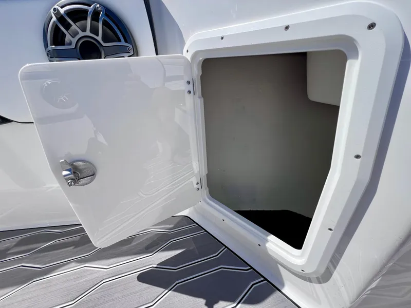 Slide: The Image of Open storage compartment on 2023 Sunsation 32 CCX boat, featuring sleek design and speaker detail. - 52