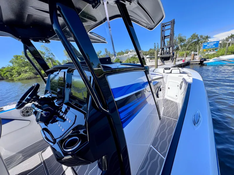 Slide: The Image of 2023 Sunsation 32 CCX boat interior with sleek design and modern controls on the water. - 55