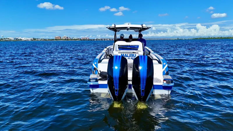 Slide: The Image of 2023 Sunsation 32 CCX boat on open water, featuring dual engines and vibrant blue accents. - 6