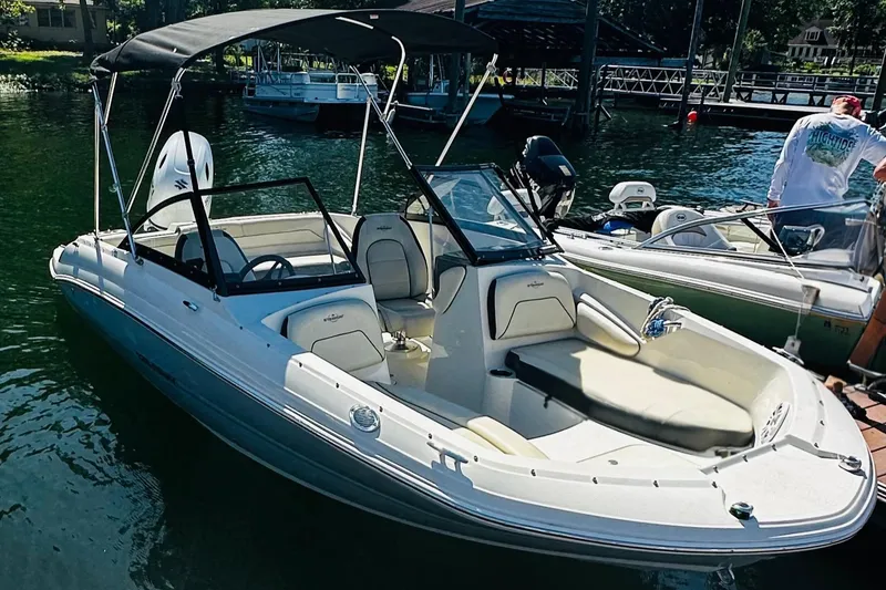 Slide: The Image of 2022 Stingray 191 DC boat docked on a sunny day, featuring a sleek design and canopy. - 12