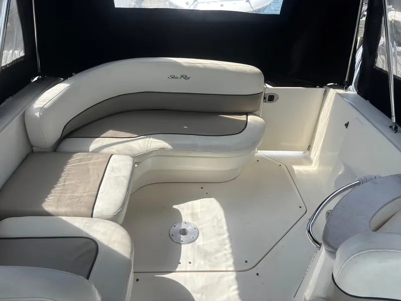 Slide: The Image of Interior of 2006 Sea Ray 260 Sundancer boat with white seating and black canopy. - 10