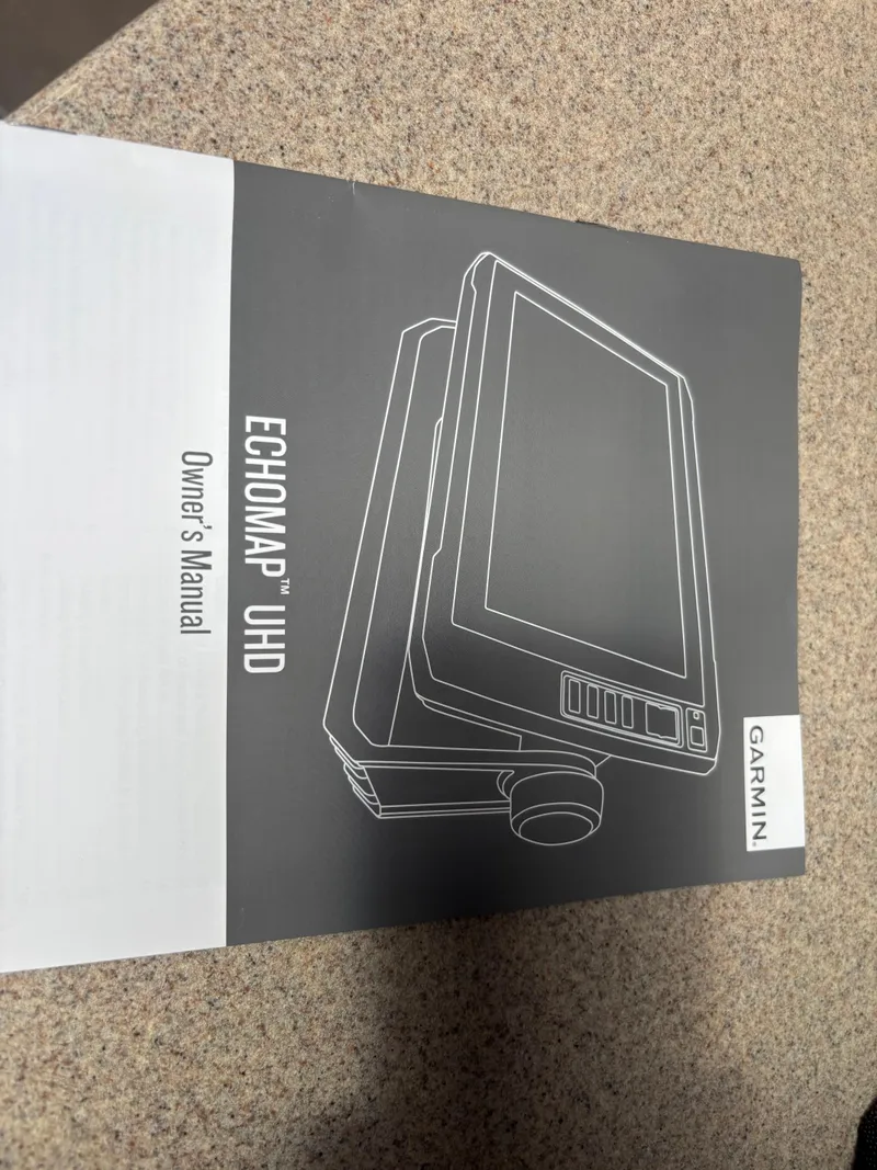 Slide: The Image of Garmin ECHOMAP UHD owner's manual on a countertop, related to Sea Ray 260 Sundancer 2006. - 16