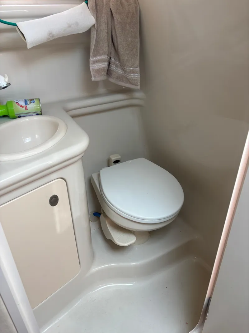 Slide: The Image of Compact bathroom in 2006 Sea Ray 260 Sundancer boat, featuring toilet and sink. - 20