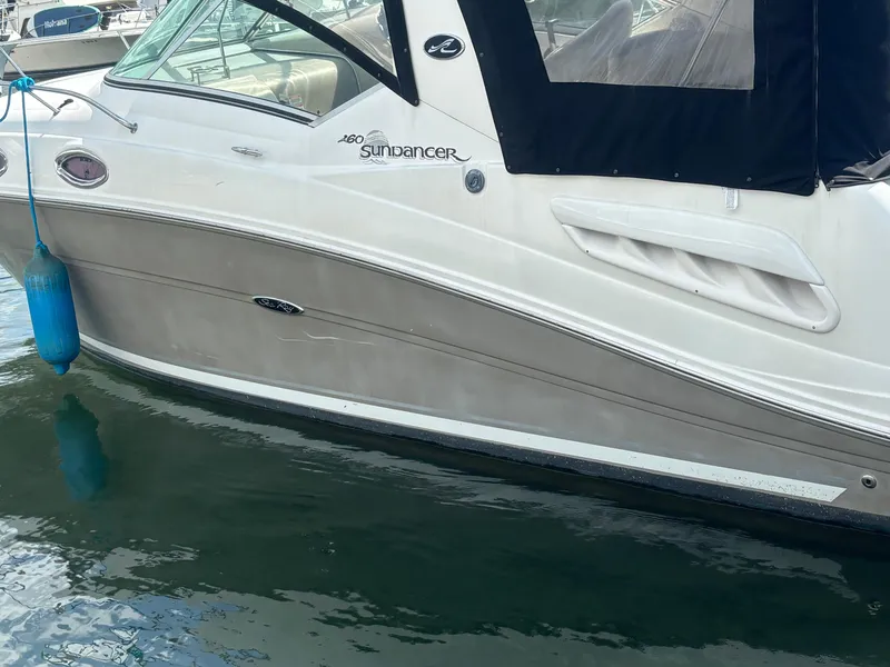 Slide: The Image of 2006 Sea Ray 260 Sundancer boat docked with blue fender, side view. - 4