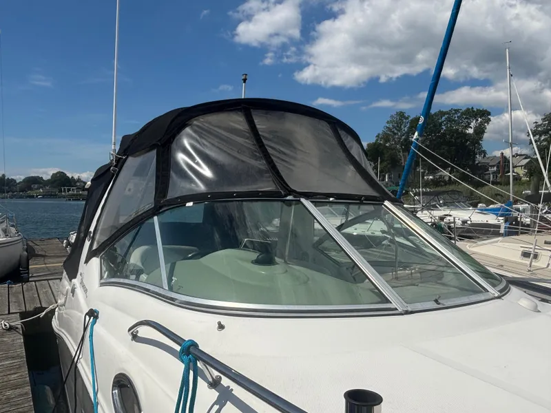 Slide: The Image of 2006 Sea Ray 260 Sundancer docked, featuring a black canopy and clear skies. - 9