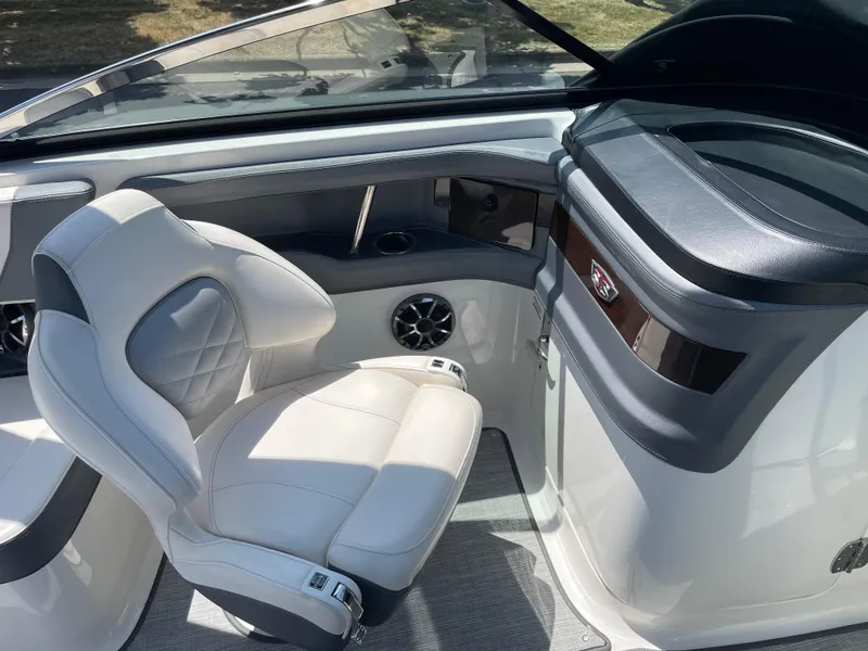 Slide: The Image of 2018 Chaparral 267 SSX boat interior with white leather seating and sleek dashboard design. - 10