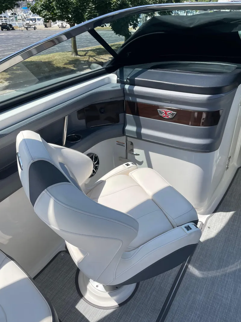 Slide: The Image of 2018 Chaparral 267 SSX boat interior with white captain's chair and dashboard. - 12