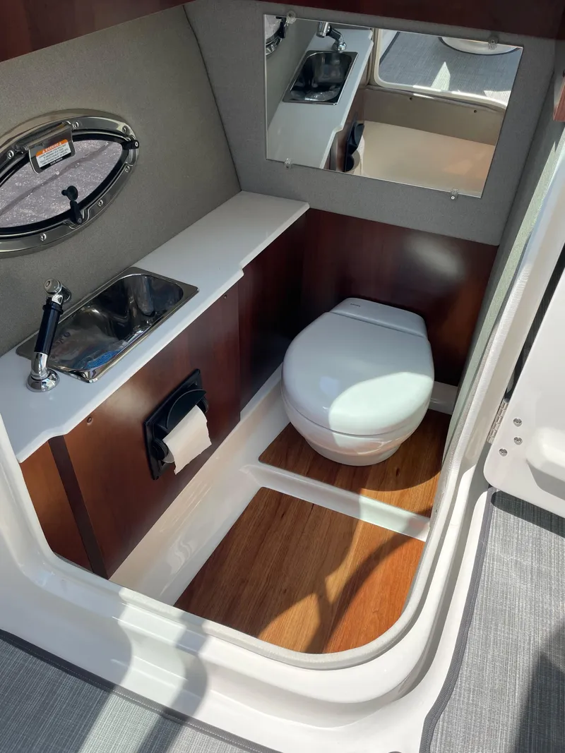 Slide: The Image of 2018 Chaparral 267 SSX boat bathroom with sink, toilet, and mirror. - 16