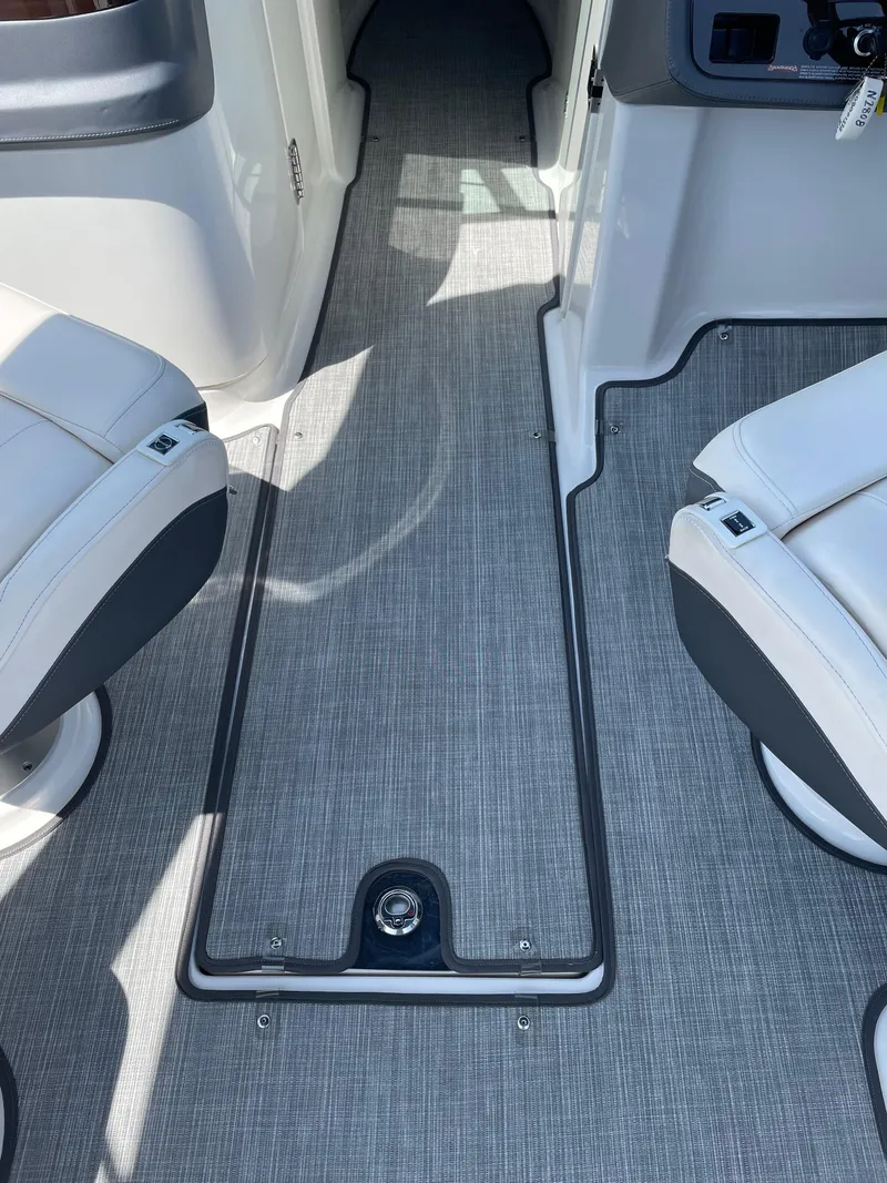 Slide: The Image of 2018 Chaparral 267 SSX boat interior with gray flooring and white seating. - 18